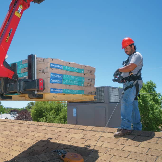 Rooftop Delivery with Crane and Contractor with Red Hard Hat